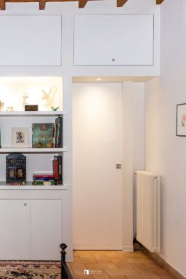 Porte coulissante à galandage avec une bibliothèque murale