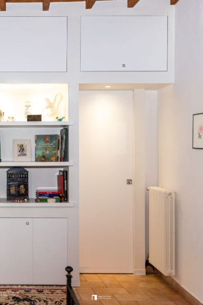 Porte coulissante à galandage avec une bibliothèque murale